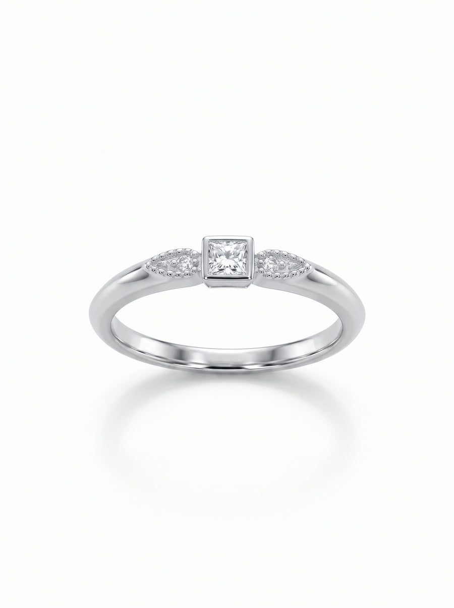 Silver engagement ring with a princess-cut center diamond and two small accent stones on a delicate band.