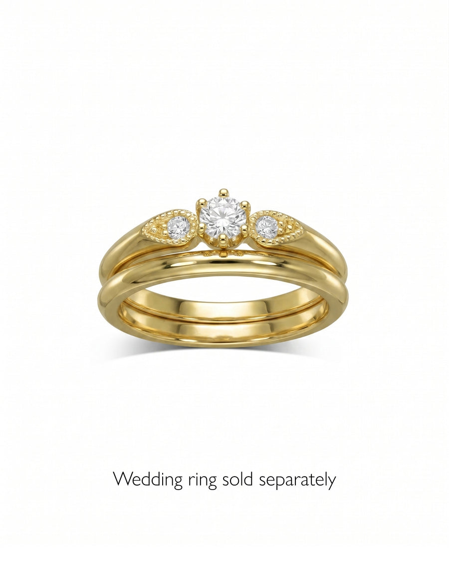 Gold vintage shoulder engagement ring with three round diamonds.