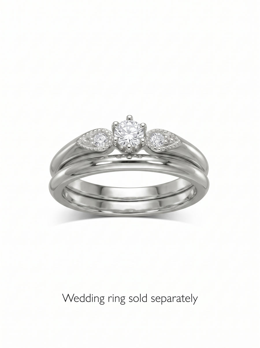 Silver engagement ring with a round center diamond and two pear-shaped side stones on a polished band.