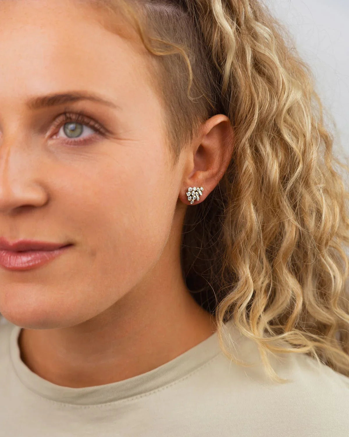 White gold diamond cluster stud earrings worn on ear, delicate modern jewelry