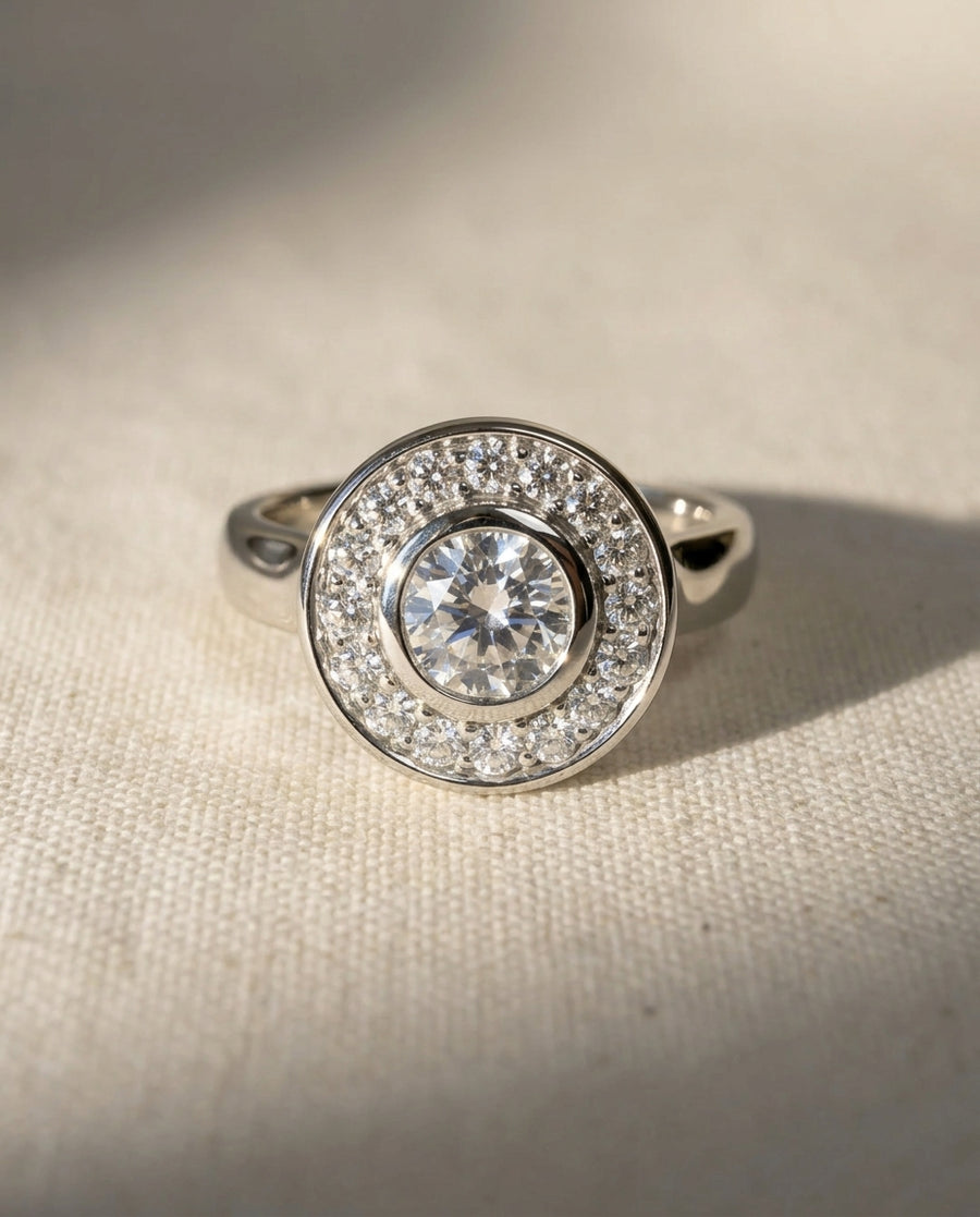 White gold diamond cluster engagement ring with a round center stone.