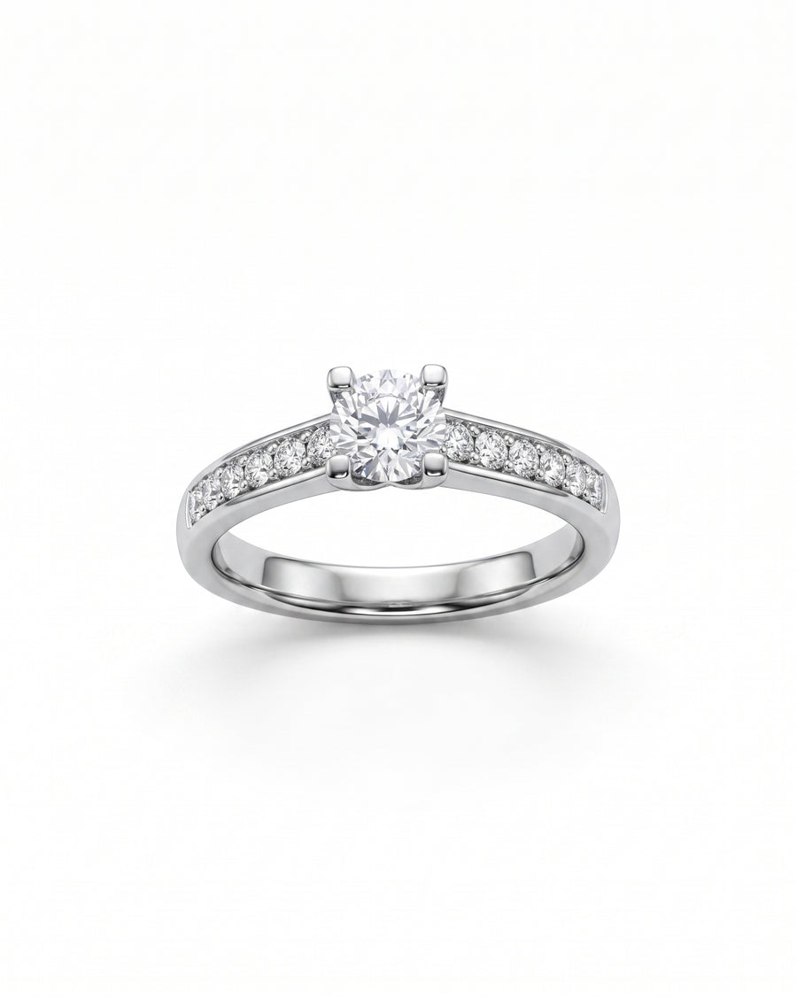 White gold engagement ring with a round diamond center stone and diamond shoulders.