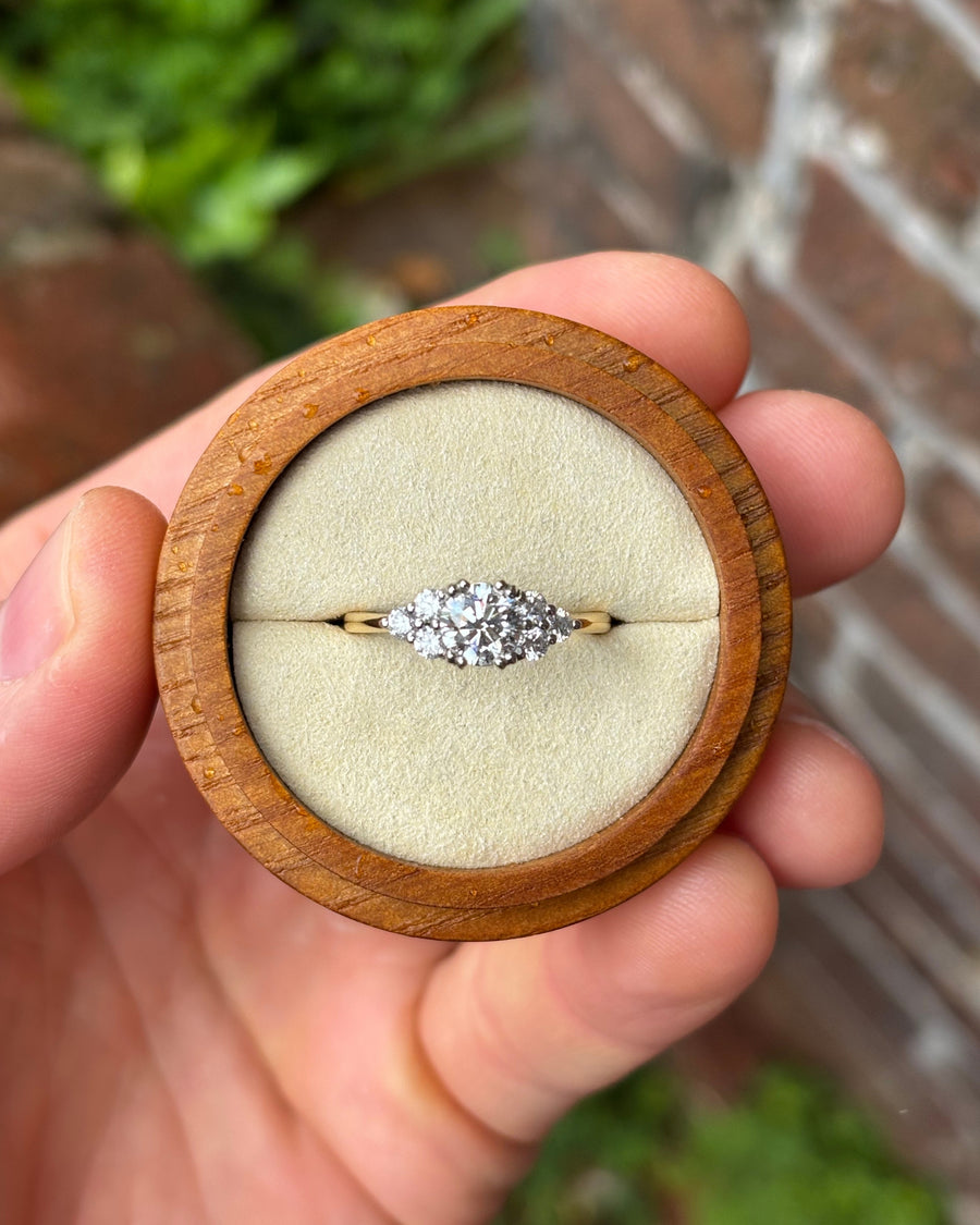 Round cut diamond engagement ring with trefoil claw setting in platinum and 18ct yellow gold.