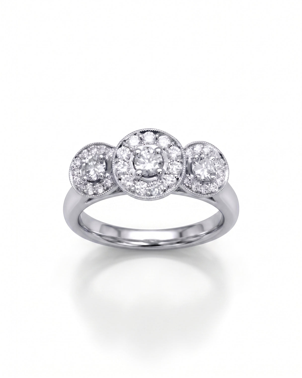 Trilogy engagement ring in white gold featuring three round diamond cluster settings with milgrain detailing.