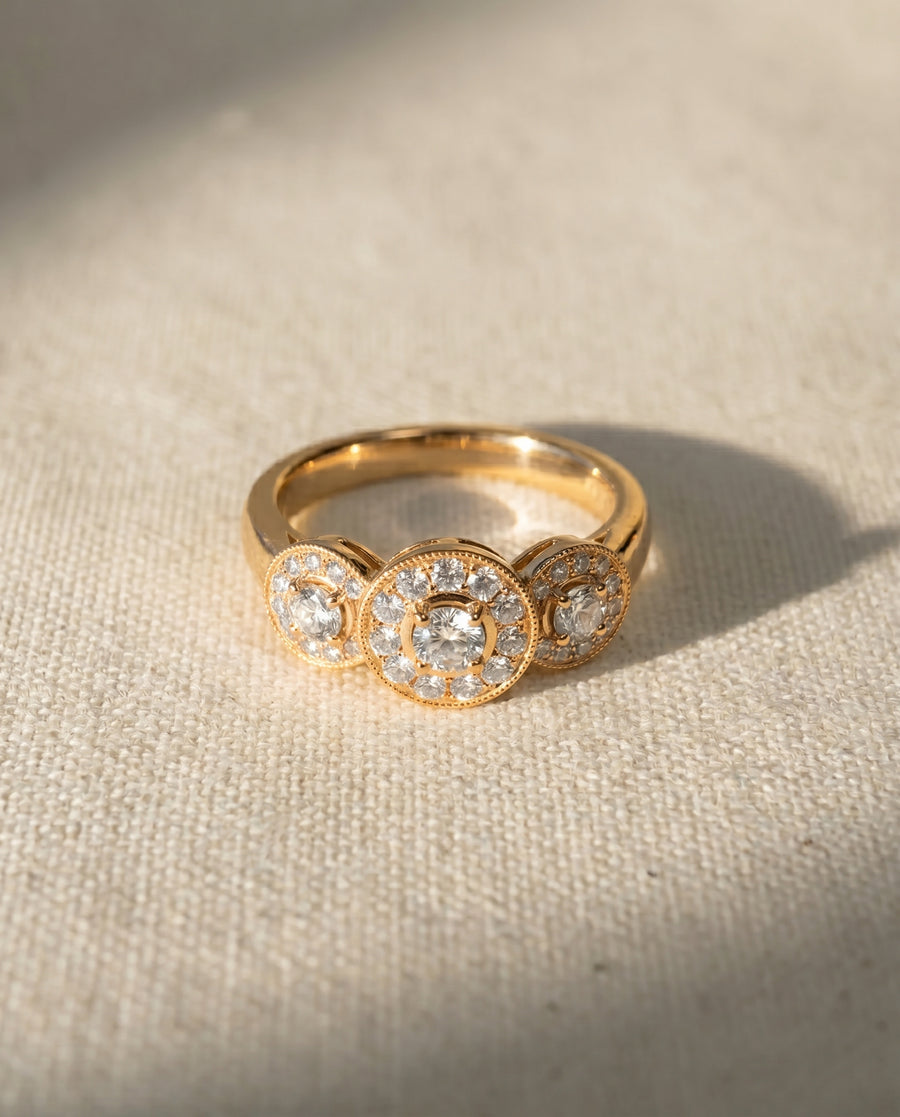 18ct yellow gold trilogy engagement ring with three round diamond clusters.