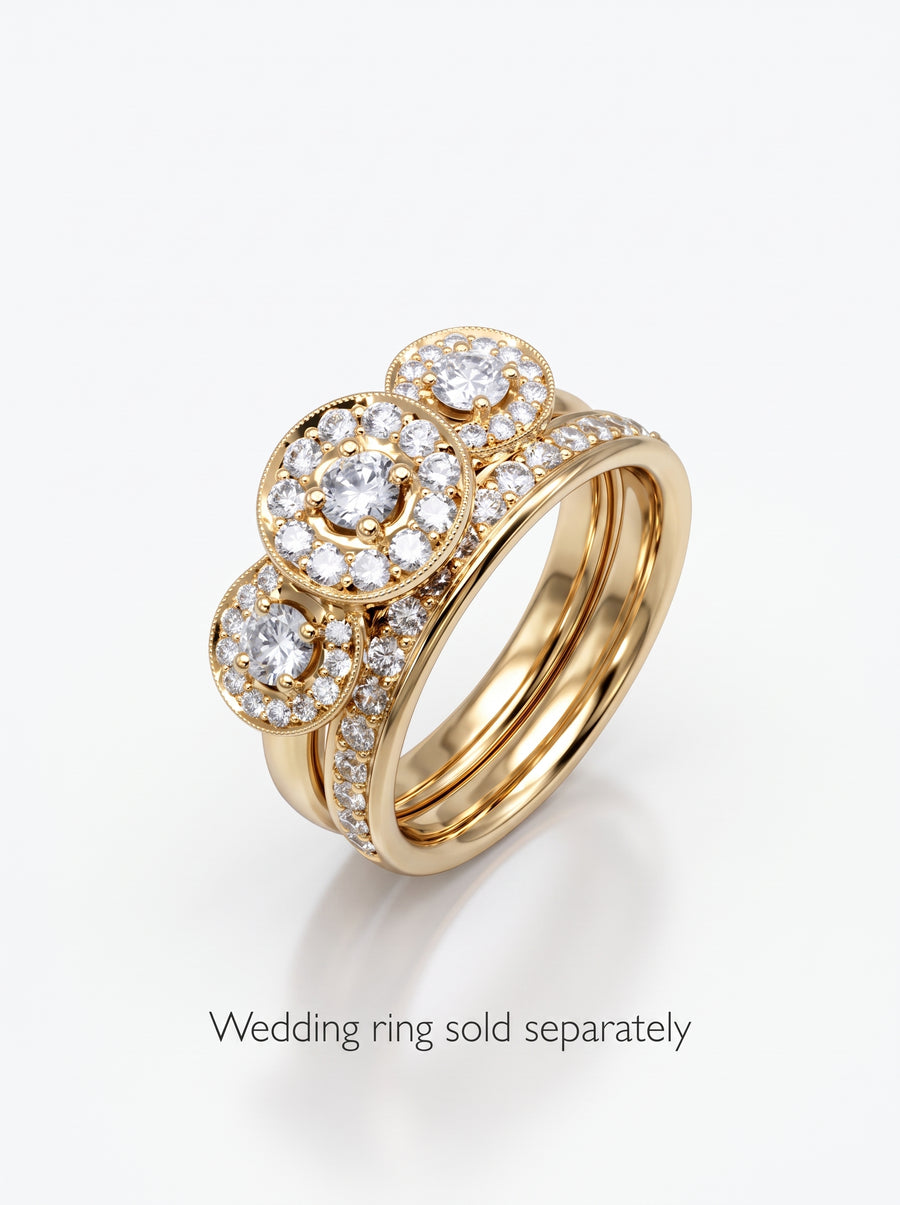 Gold trilogy cluster engagement ring featuring three round diamond halos on a pavé diamond band.