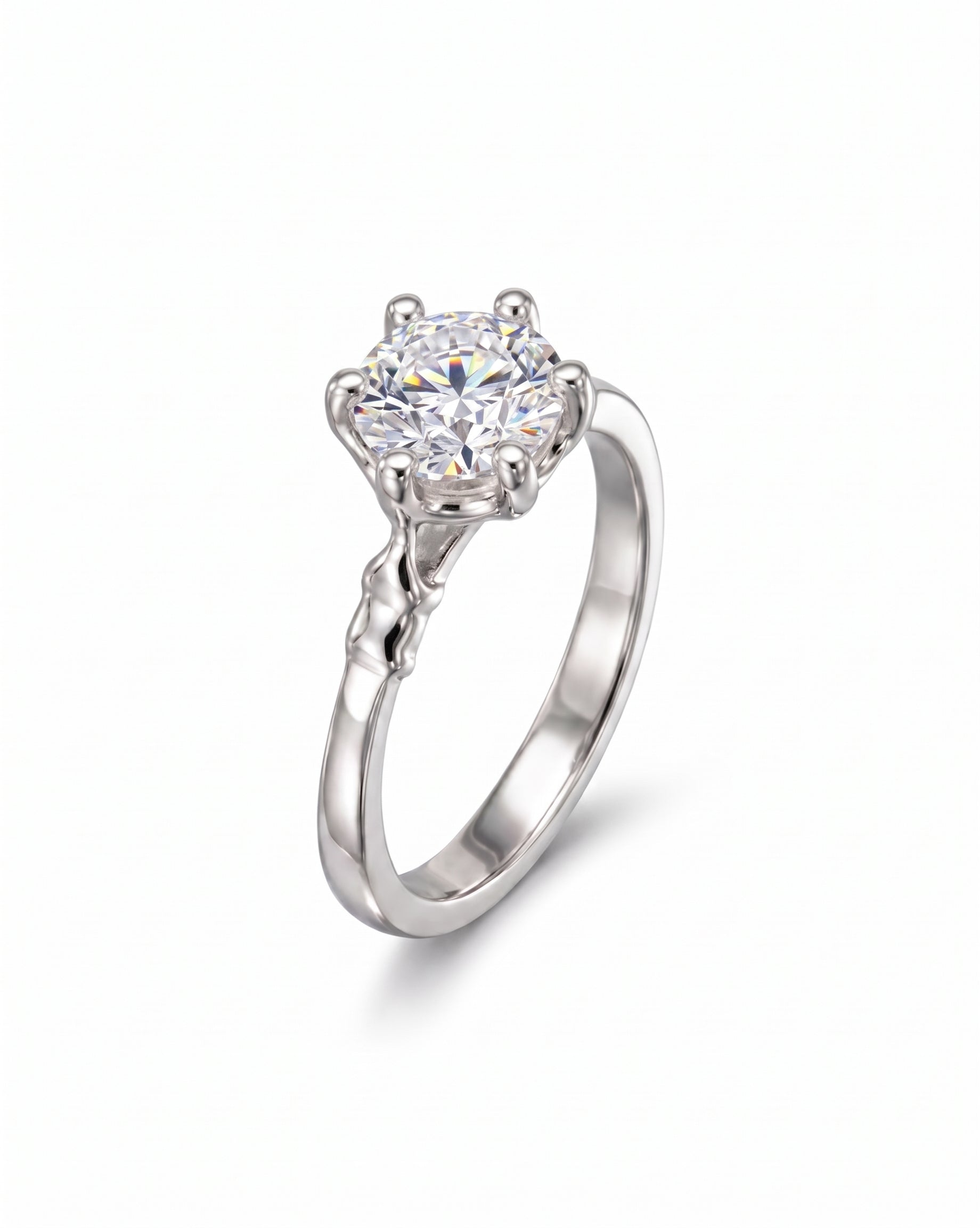 Silver engagement ring with a large round diamond and elephant motif prongs.
