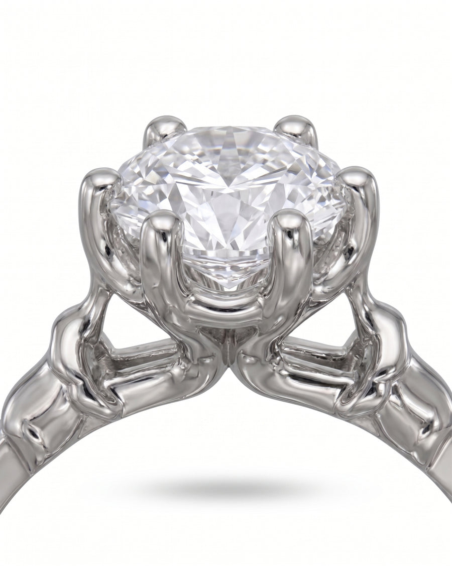 White gold engagement ring with a round diamond in an elephant motif setting.