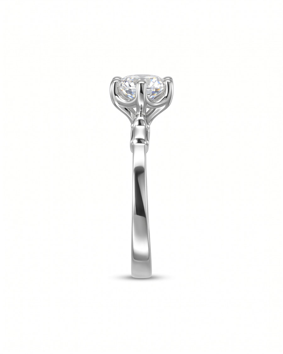 Silver engagement ring with a round diamond and elephant motif setting.