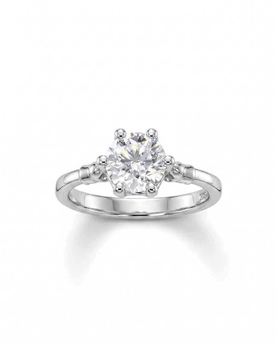 Silver engagement ring with a round diamond in a six-prong setting.