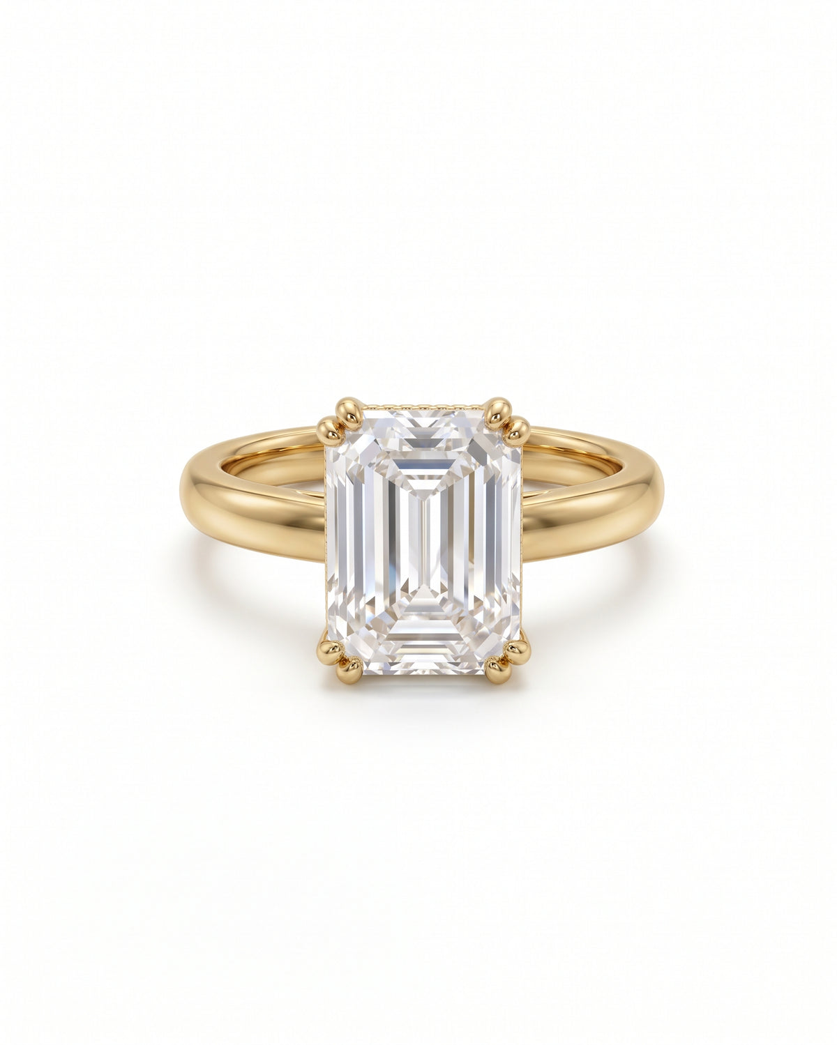 Emerald-cut solitaire engagement ring in 18ct yellow gold with a cathedral setting on a white background.