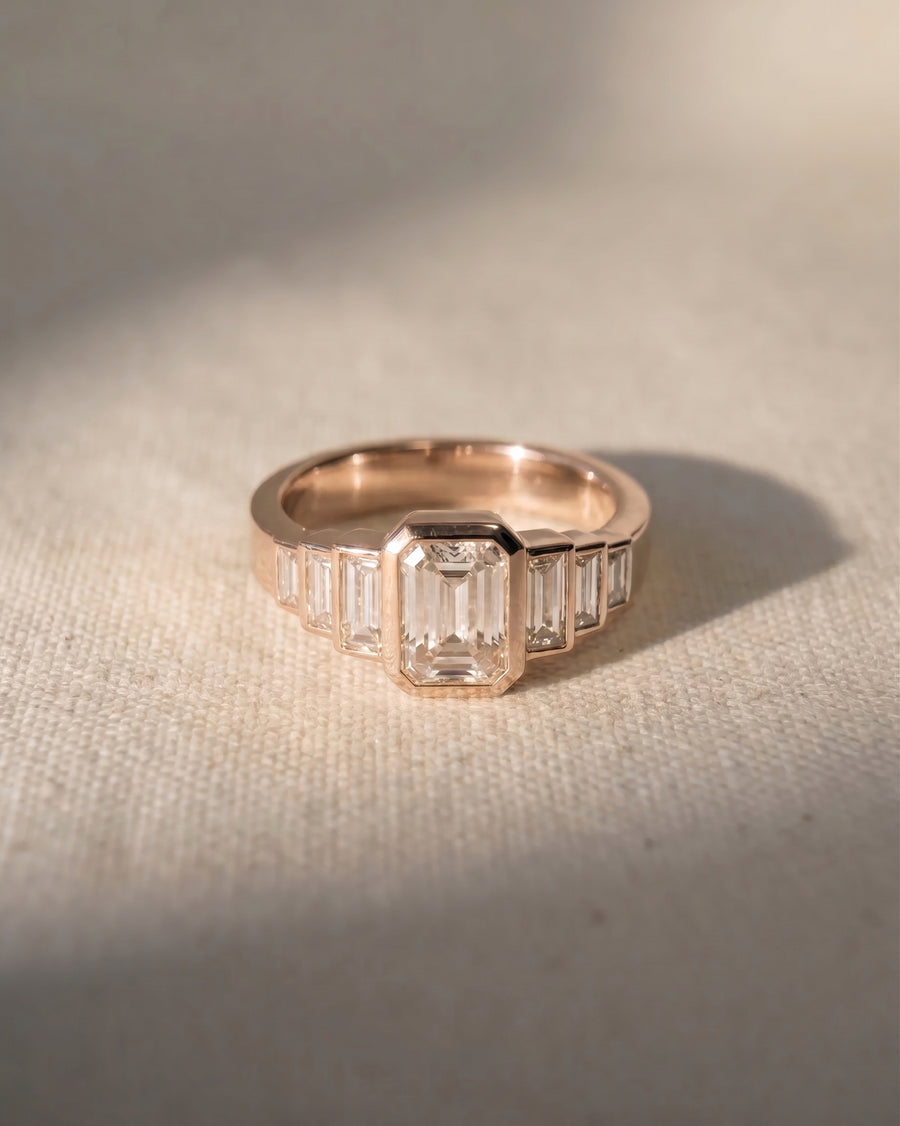 18ct rose gold engagement ring with an emerald cut lab grown diamond and baguette side stones.