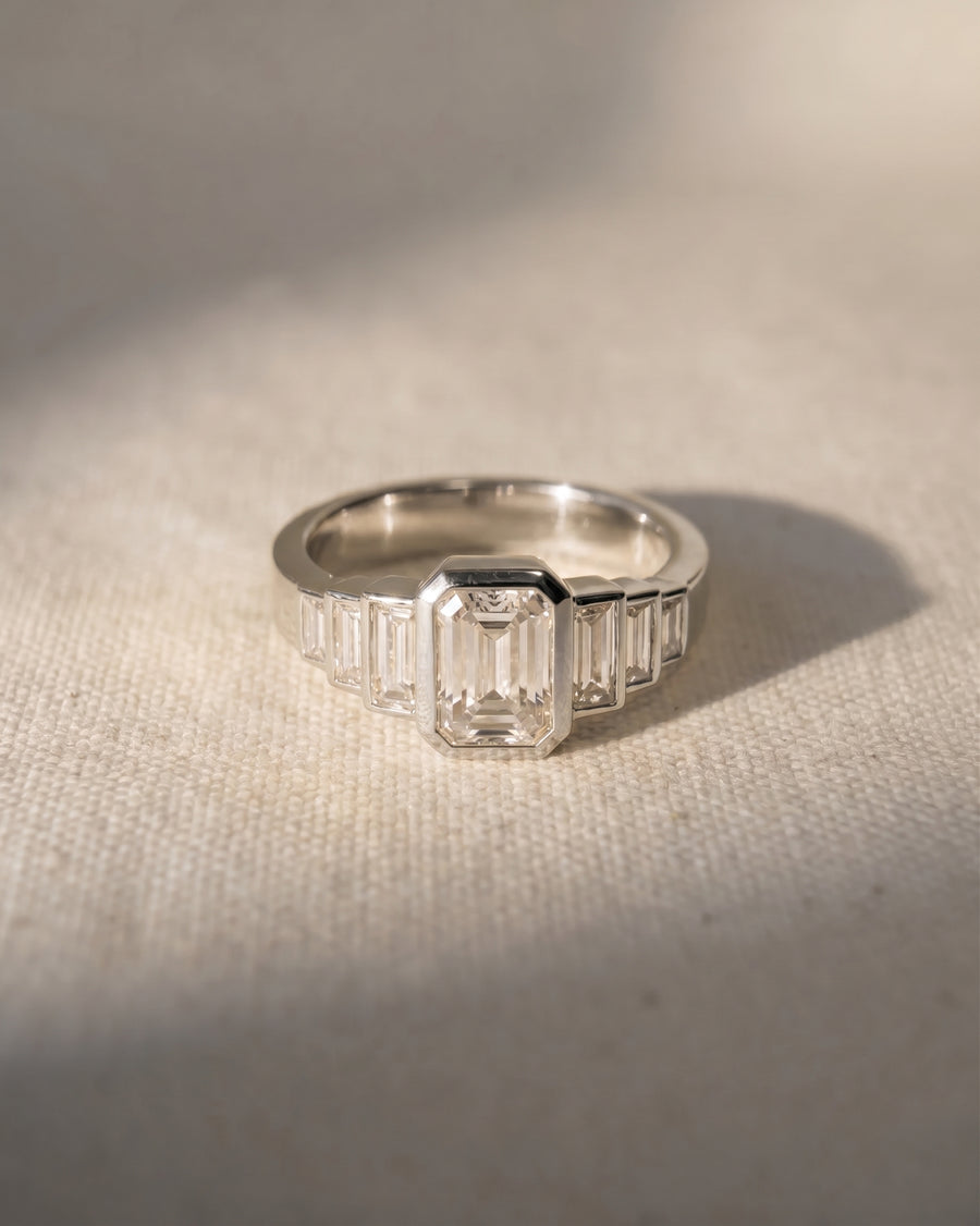 Platinum emerald cut diamond engagement ring with baguette side stones.