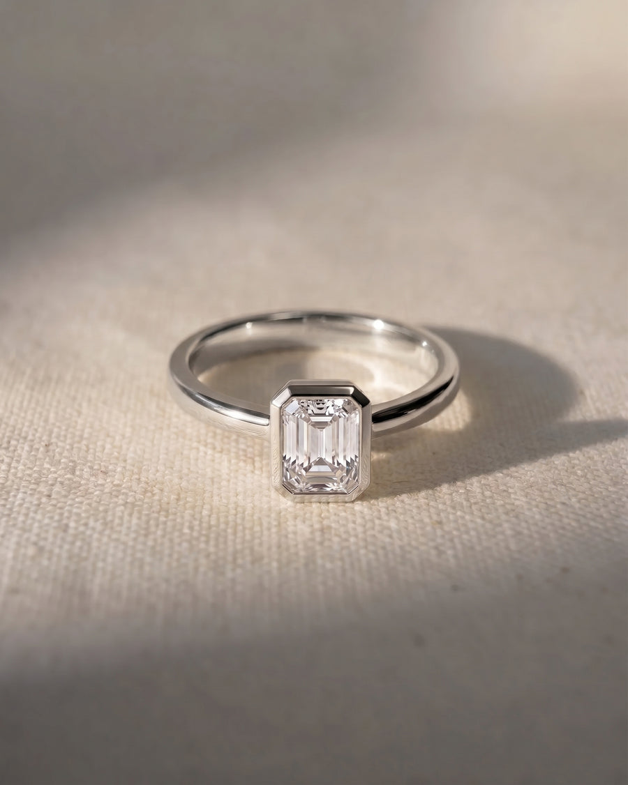 Platinum emerald cut bezel engagement ring with a 1ct lab-grown diamond.
