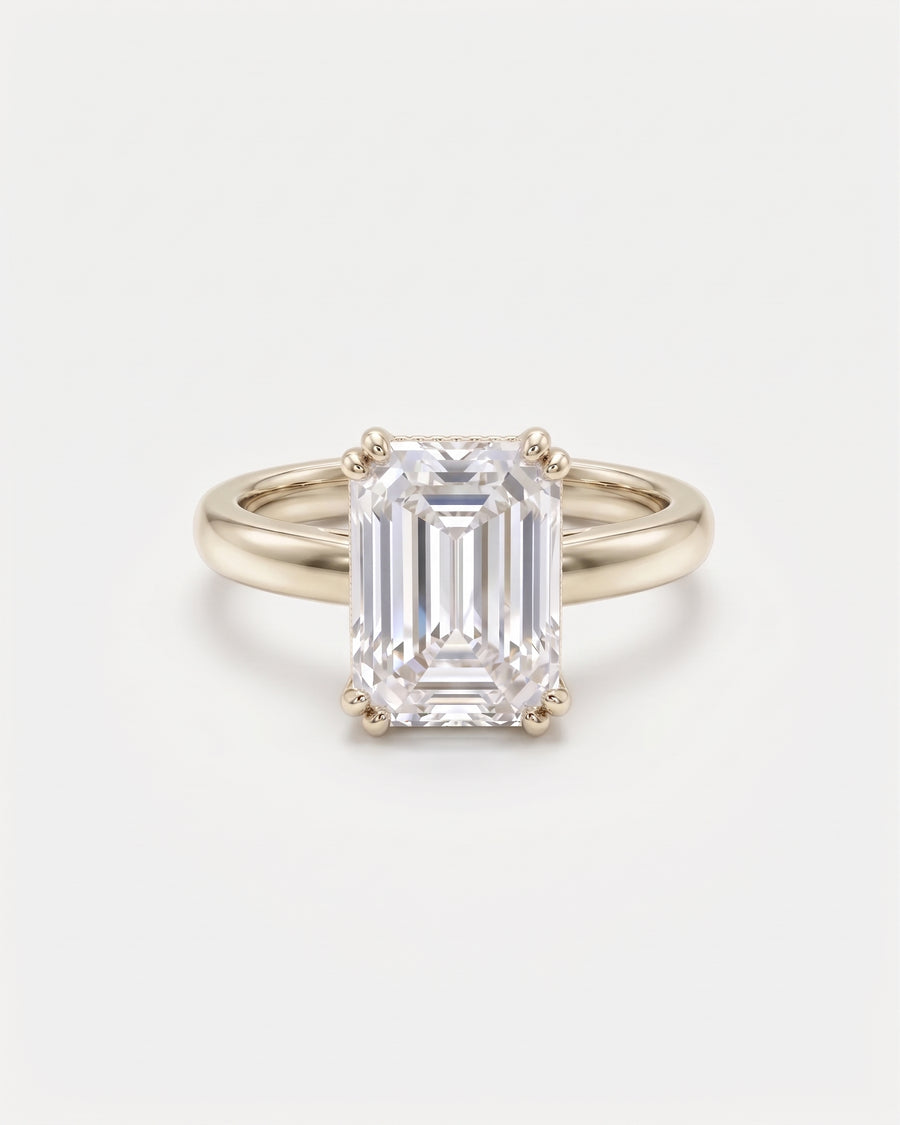 Emerald-cut solitaire engagement ring in 9ct white gold with a cathedral setting on a plain band.