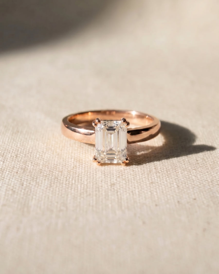 18ct rose gold emerald-cut cathedral solitaire engagement ring.