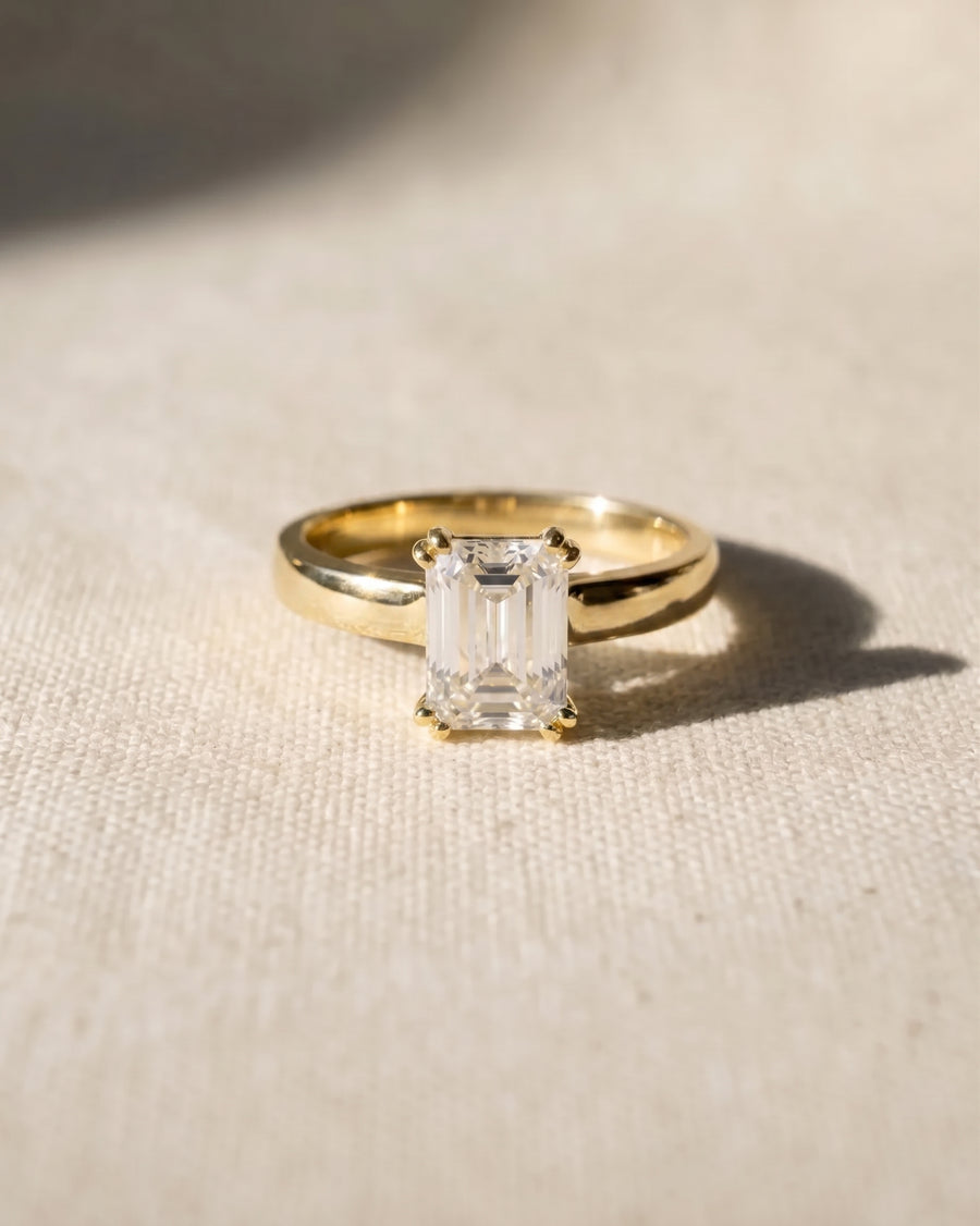 18ct yellow gold emerald-cut cathedral solitaire engagement ring.