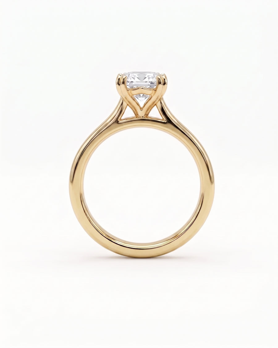 Gold cathedral solitaire engagement ring with an emerald-cut diamond.