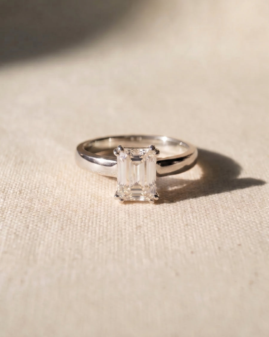 Platinum emerald-cut cathedral solitaire engagement ring.
