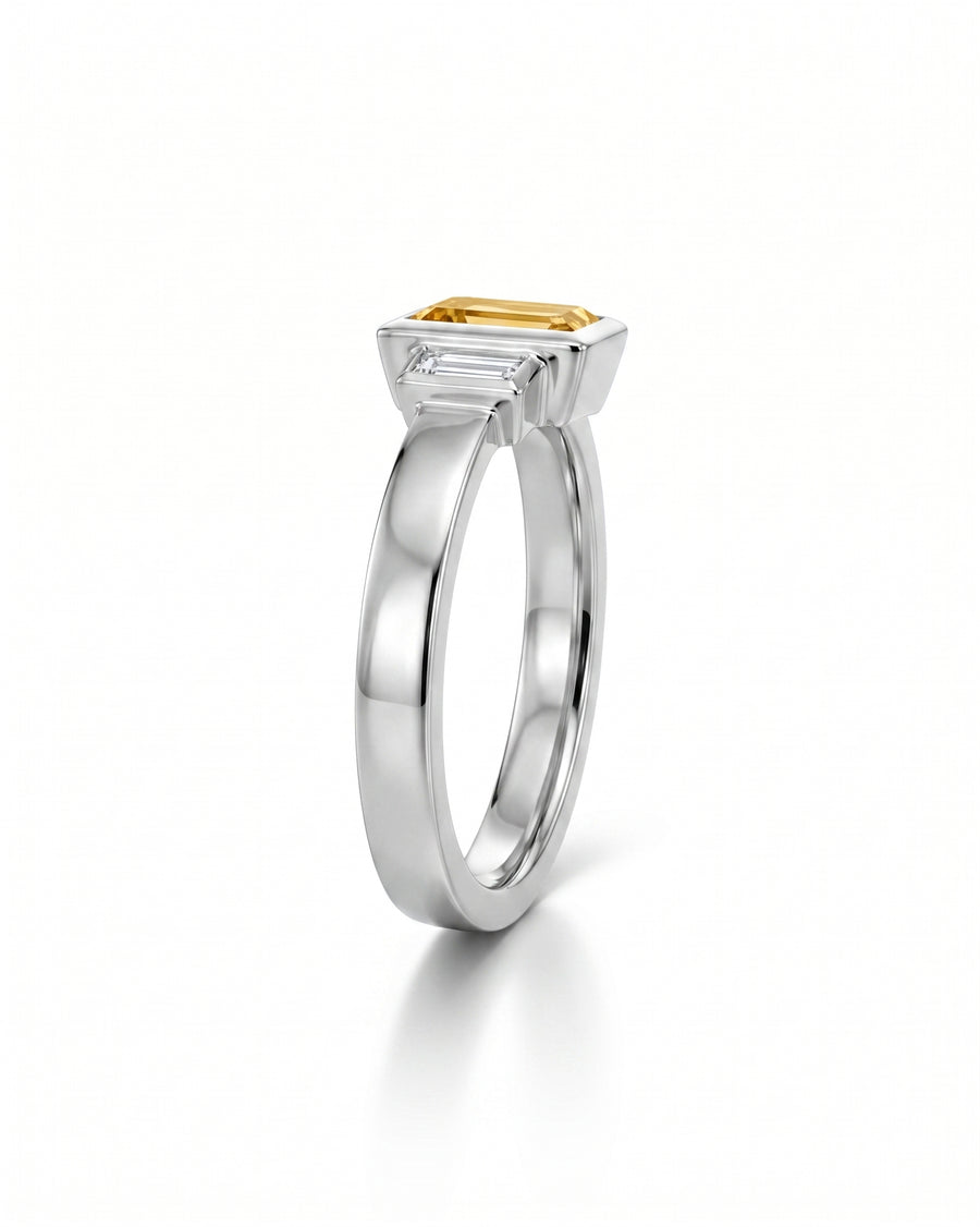 Silver ring with an emerald cut cognac diamond and two baguette diamonds.