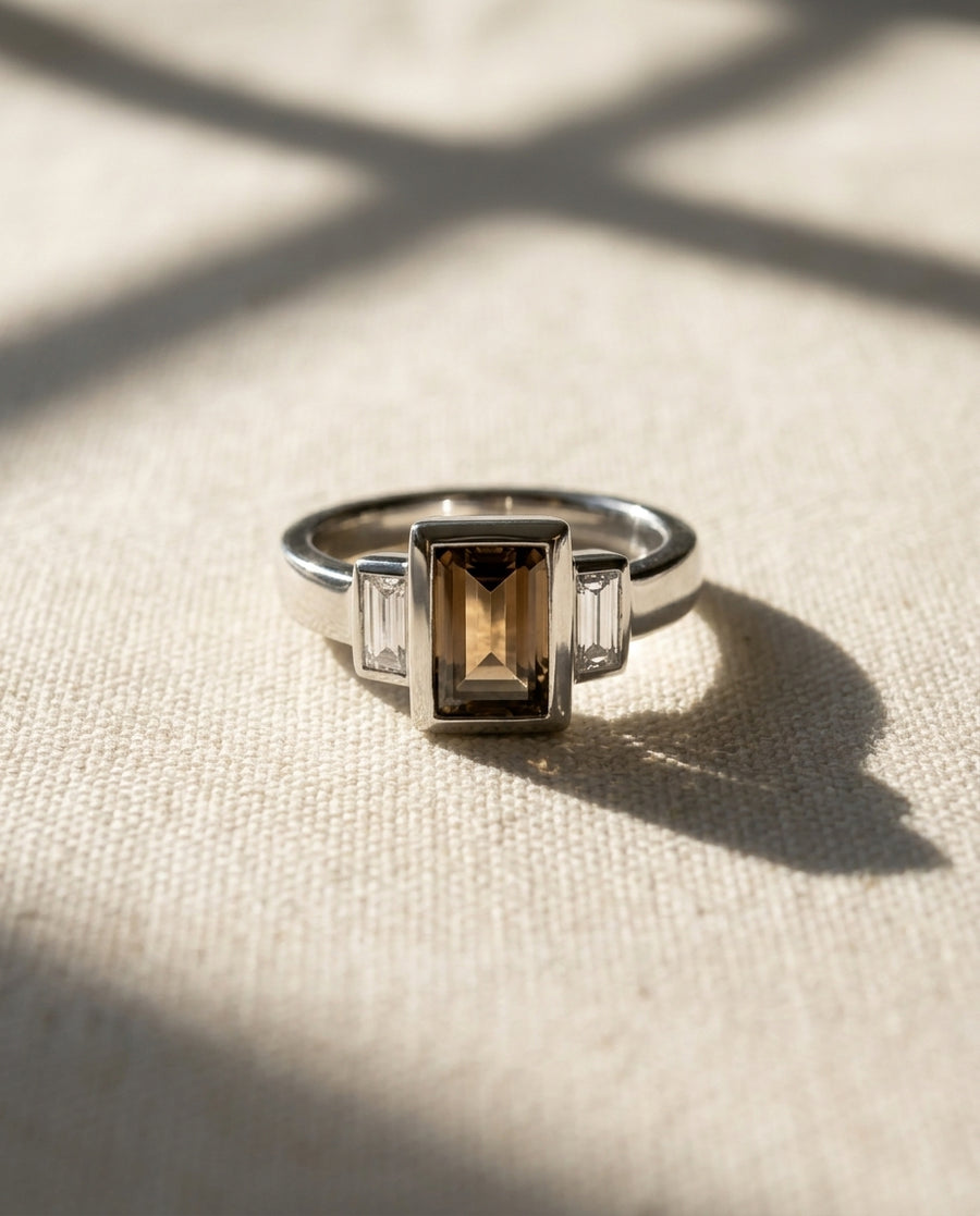 Platinum ring with emerald cut cognac diamond and baguette side stones.