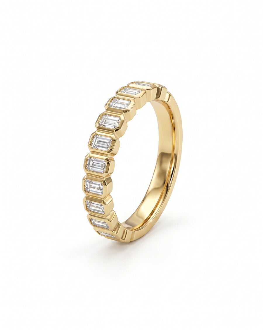 Yellow gold eternity ring with bezel-set emerald cut diamonds.