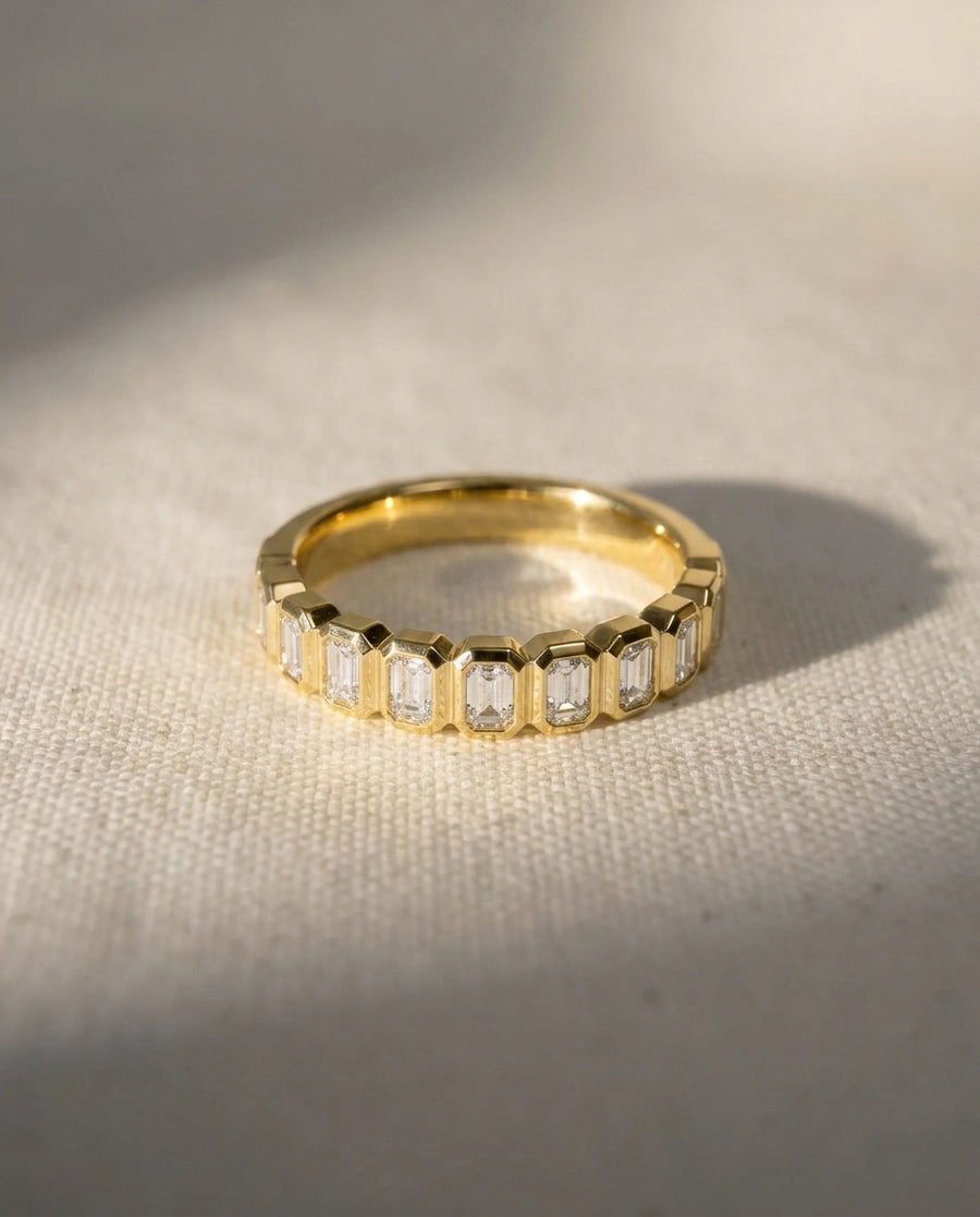 9ct yellow gold eternity ring with bezel-set emerald cut diamonds.