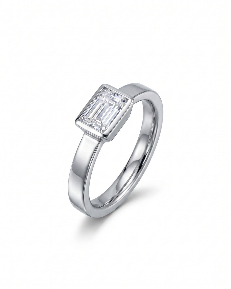 Platinum engagement ring with an emerald cut diamond.