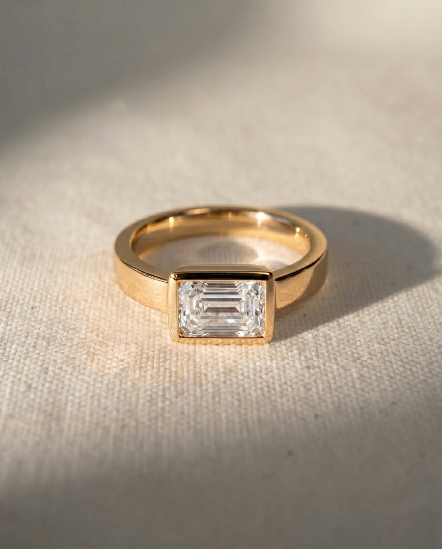 18ct yellow gold engagement ring with an emerald cut diamond.