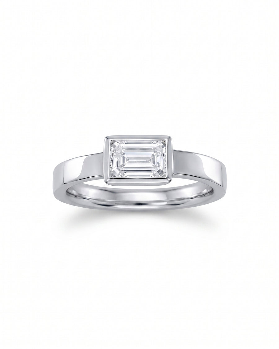 Platinum engagement ring with an emerald cut diamond.
