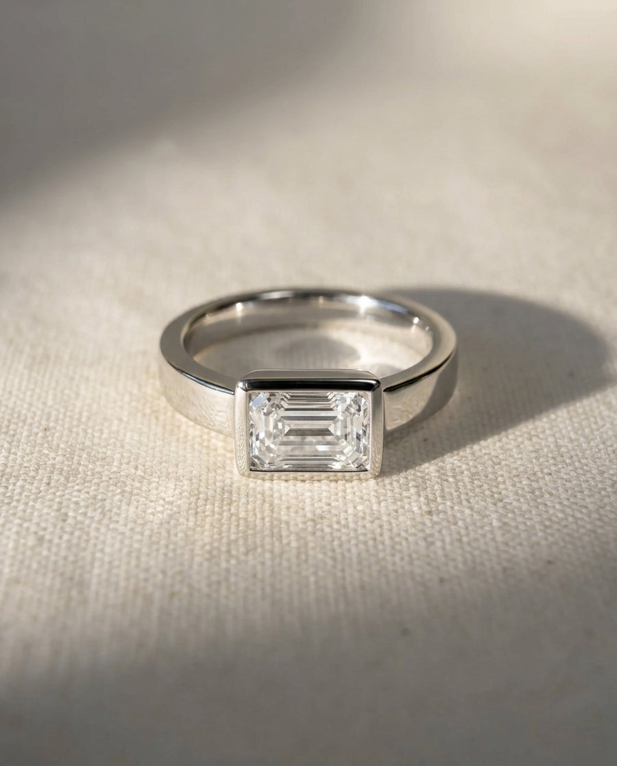 Platinum engagement ring with an emerald cut diamond.