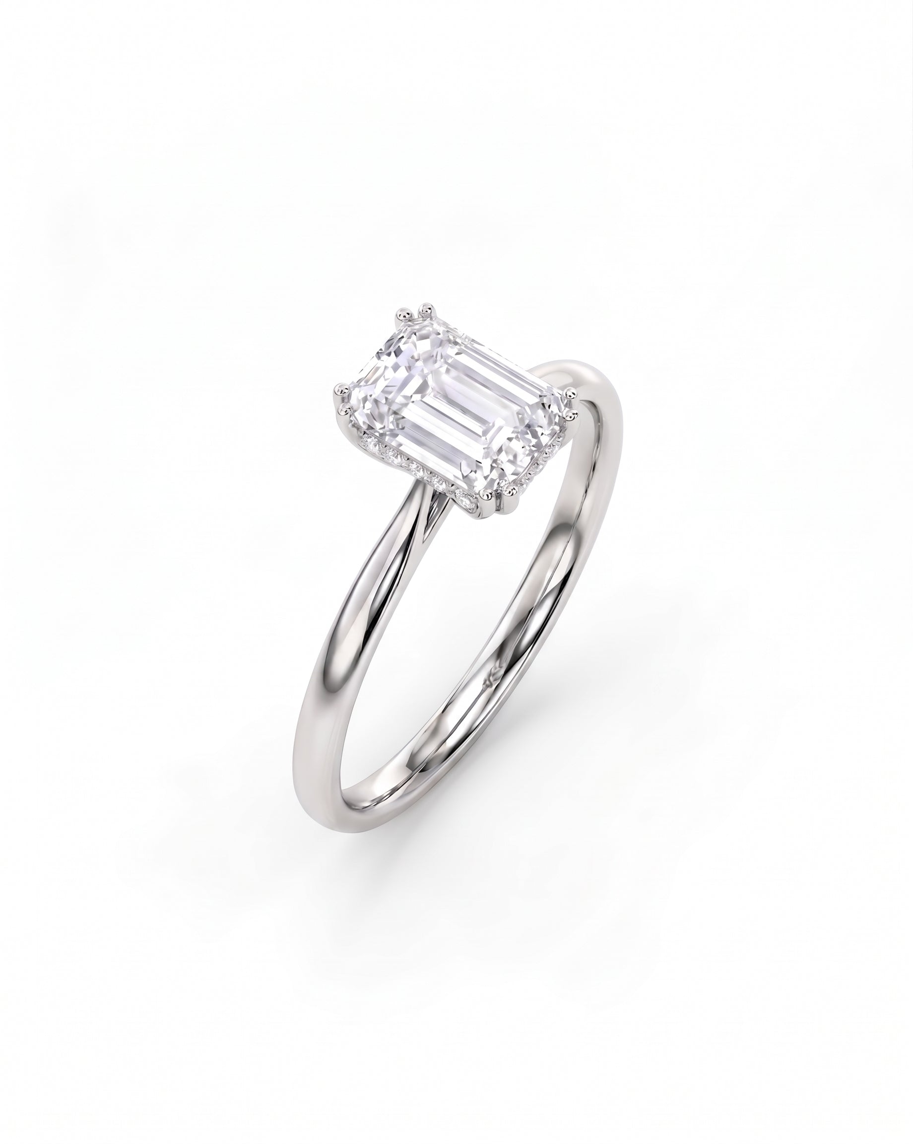 White gold engagement ring with an emerald cut diamond and hidden halo.