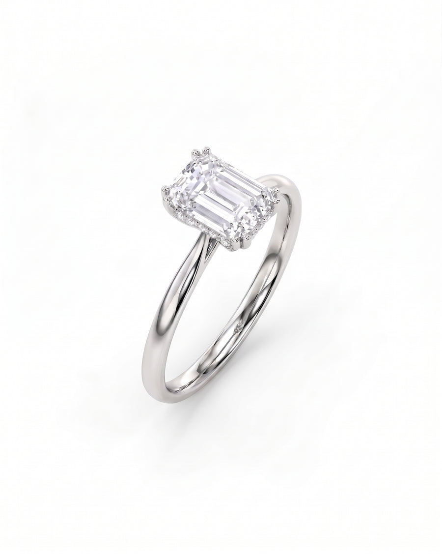 Silver engagement ring with an emerald cut diamond and hidden halo.