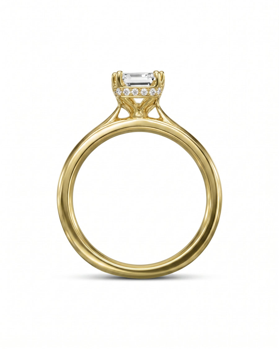 Yellow gold engagement ring with an emerald cut diamond and hidden halo.