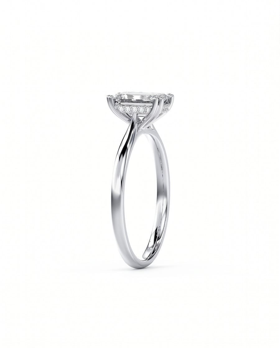 Silver engagement ring with an emerald cut diamond and hidden halo.