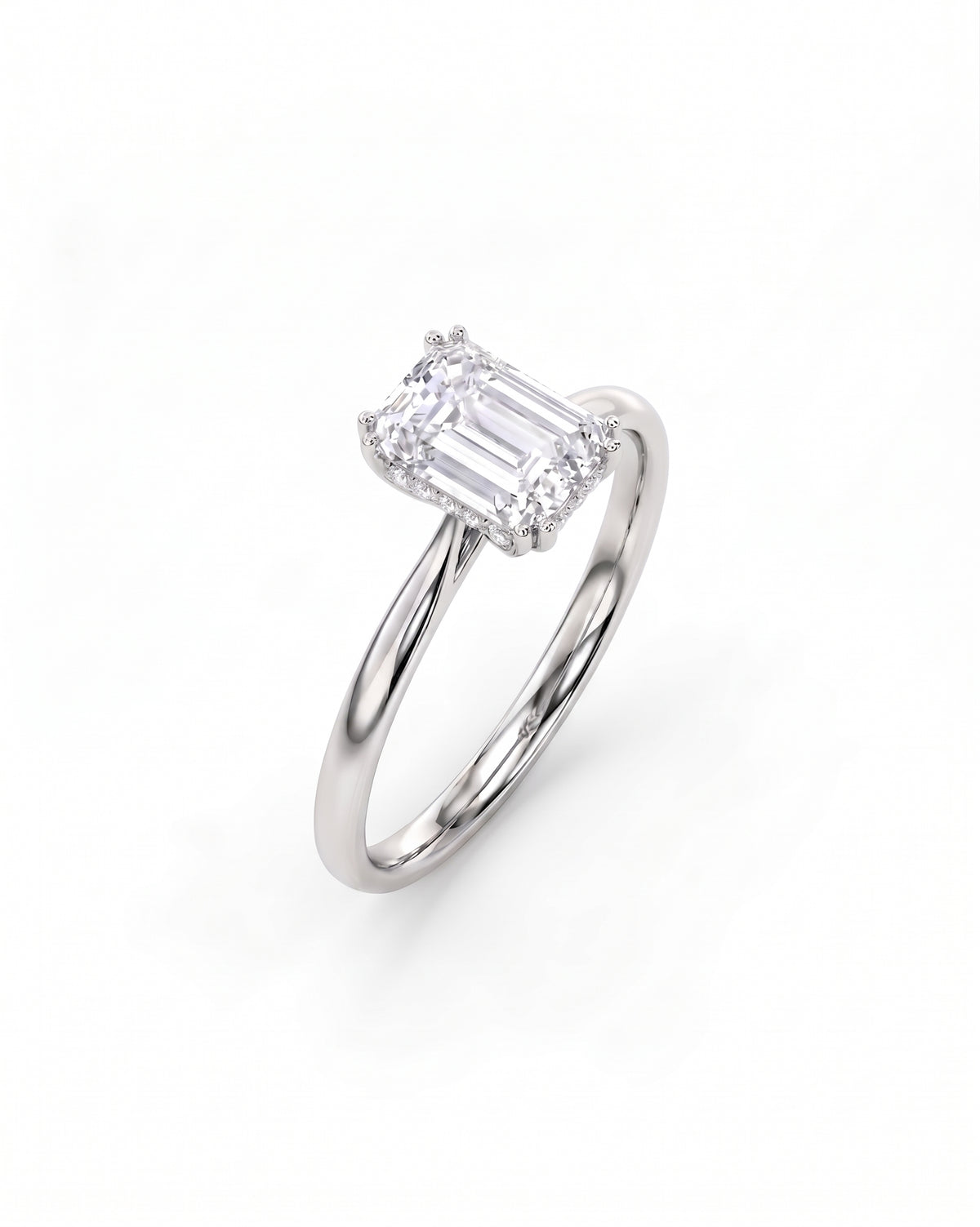 Emerald cut diamond engagement ring with a hidden halo on a polished silver band.