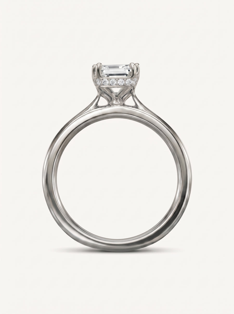 Emerald cut diamond engagement ring in platinum with a hidden halo of small round diamonds.