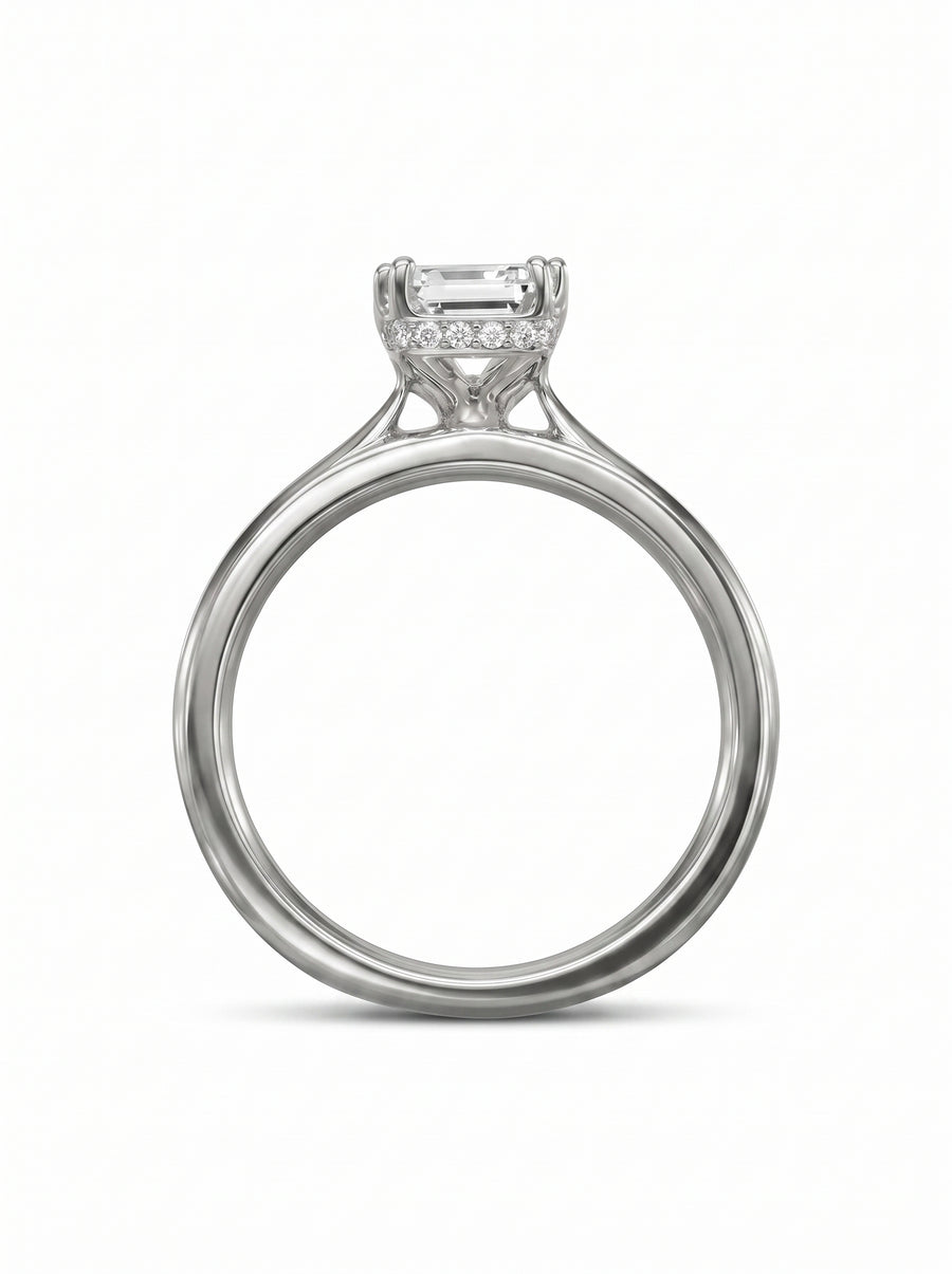 Emerald cut diamond engagement ring in platinum with a hidden halo of small round diamonds.