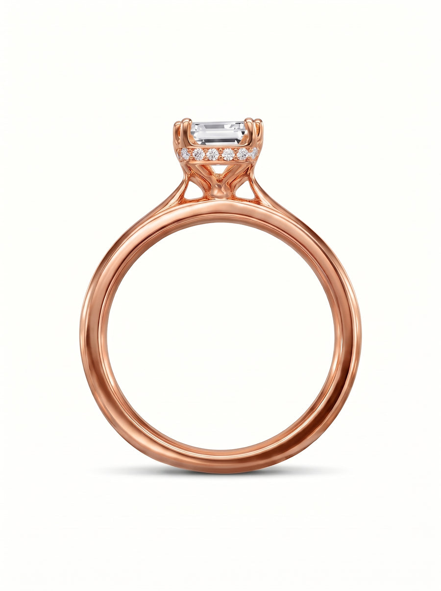 Rose gold engagement ring featuring an emerald cut center diamond with a pavé hidden halo setting.