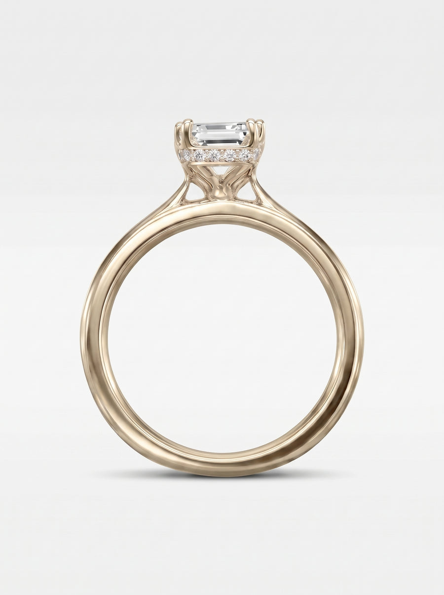 Emerald cut diamond engagement ring in yellow gold with a pavé hidden halo setting.
