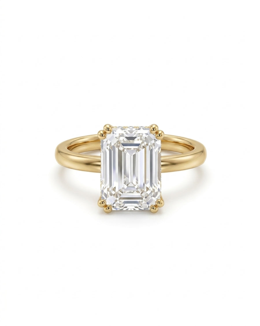 Emerald cut diamond engagement ring with a hidden halo set in 18ct yellow gold.