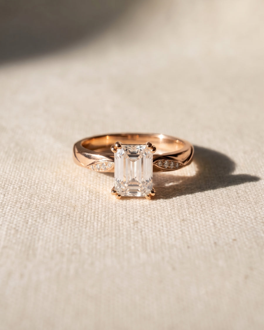 18ct rose gold engagement ring with a 1ct lab-grown emerald cut diamond and pavé accents.