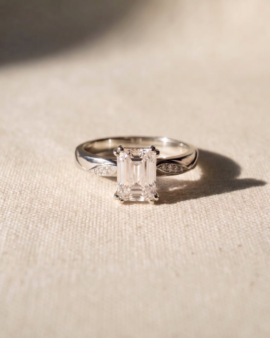 Platinum engagement ring with an emerald cut lab-grown diamond and pavé accents.