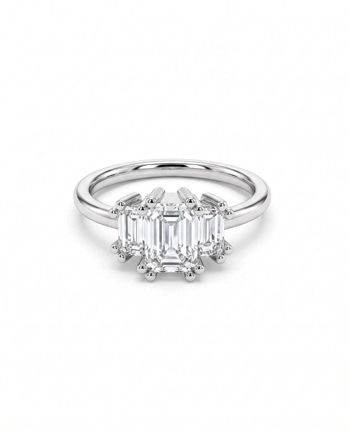 Three-stone engagement ring with emerald-cut diamonds set in polished white gold with claw prongs.