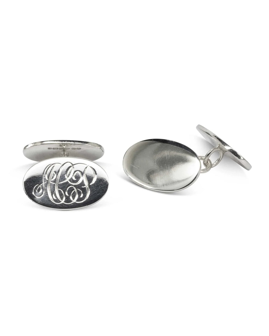 Oval silver cufflinks with engraved initials and a chain link connector on a white background.