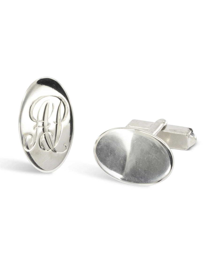 Polished silver oval cufflinks with a clip back, one featuring engraved script initials.