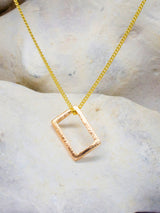 Simple gold square hammered every day pendant on rock background