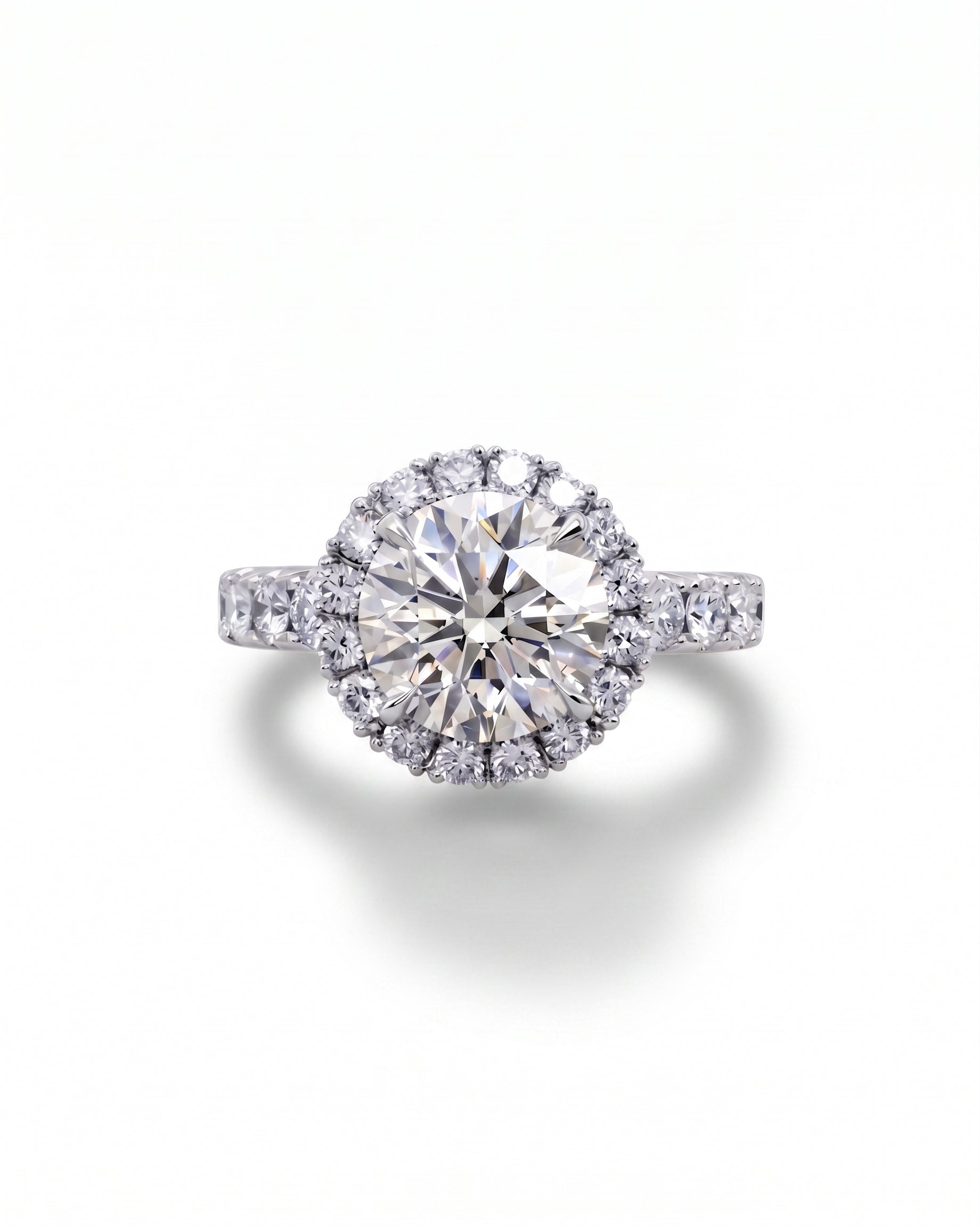 White gold engagement ring with a large round diamond surrounded by a halo of smaller diamonds.