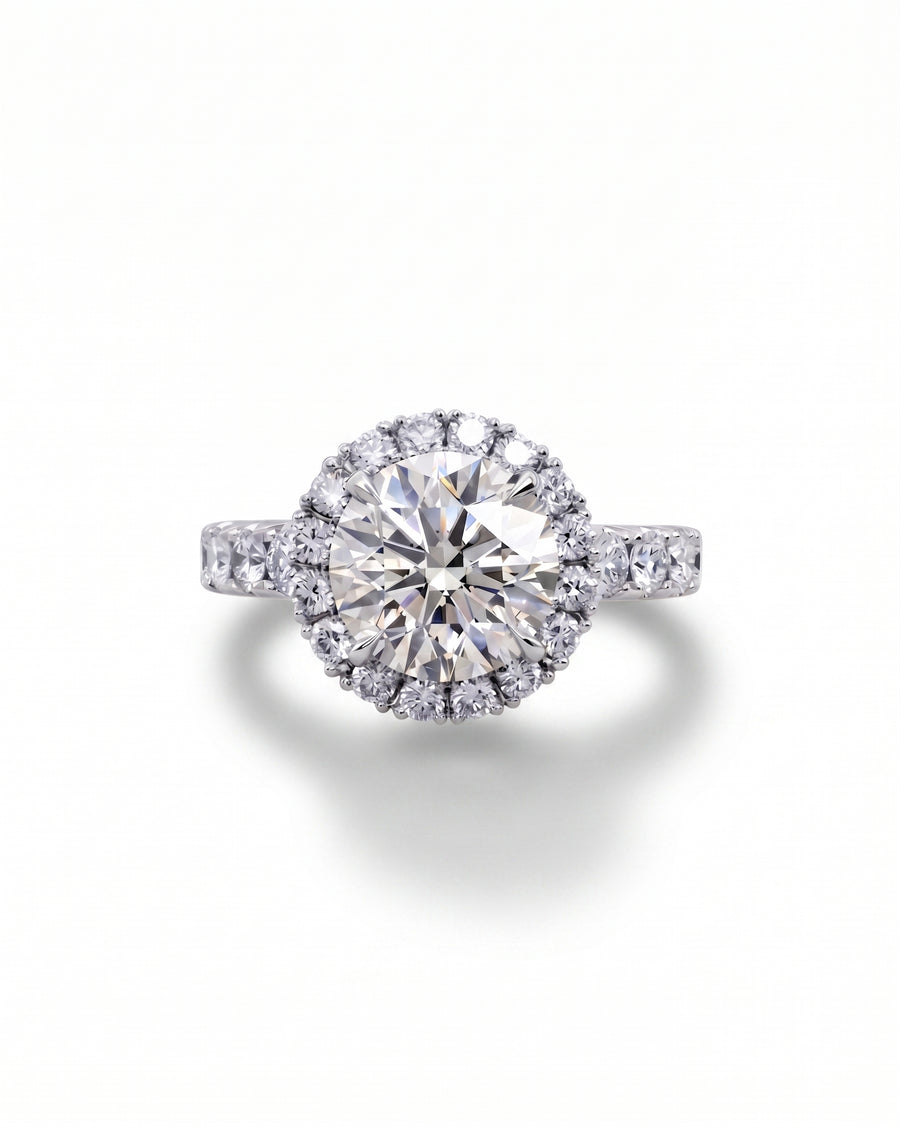 White gold engagement ring with a large round diamond surrounded by a halo of smaller diamonds.