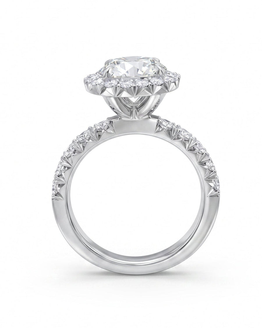 Silver engagement ring with a large round diamond and halo, set on a pavé band.